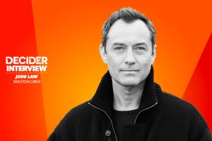 Jude Law in black and white on a bright orange background